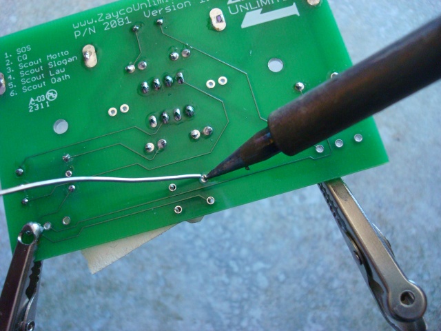 A picture of the button being soldered.